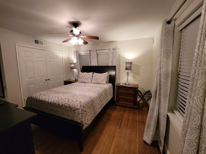 Მთავარ საძინებელში არის საწოლი და ჭერის ვენტილატორი დიდი ზომის. Გაშალეთ ფარდები. 