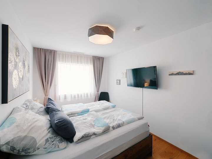 kleines Schlafzimmer mit Smart TV & Ladekabel für Smartphones / kleines Schlafzimmer mit Smart  TV & Ladekabel für Smartphones