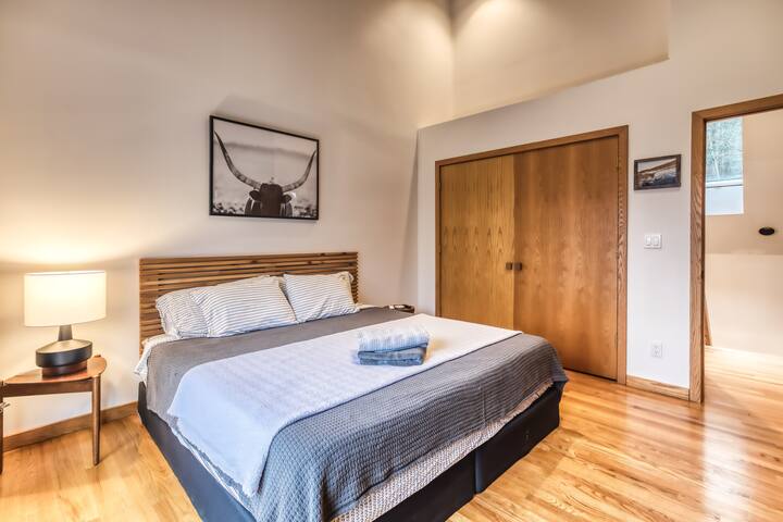 Los techos abovedados en este dormitorio superior dan una sensación muy espaciosa. También se abre a un balcón frente al lago. La cama King Tempur-pedic® te impresionará.