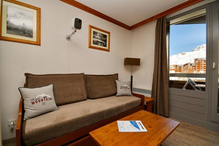 סלון עם ספה נפתחת ומרפסת עם נוף להרים.