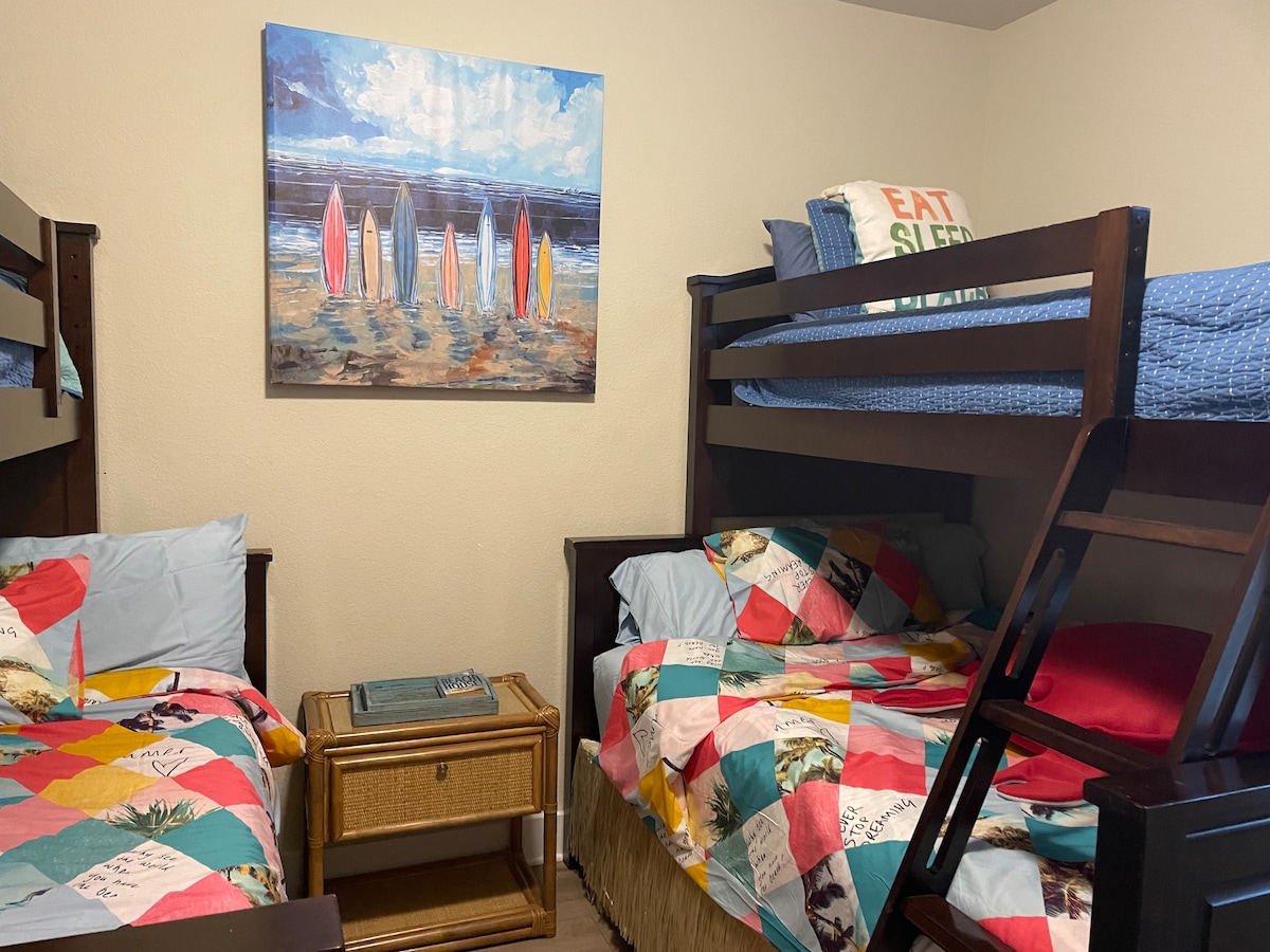 спалня за сърф с 2 комплекта двуетажни легла с две единични легла в горната част на долния смарт телевизор