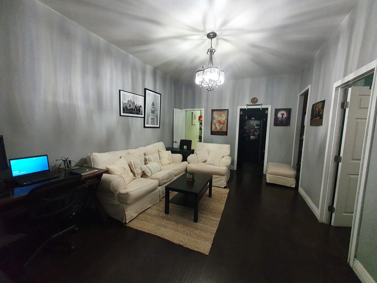 Sala de estar desde la entrada principal, baño a la izquierda, entrada a la cocina en el centro y puerta del dormitorio a la derecha