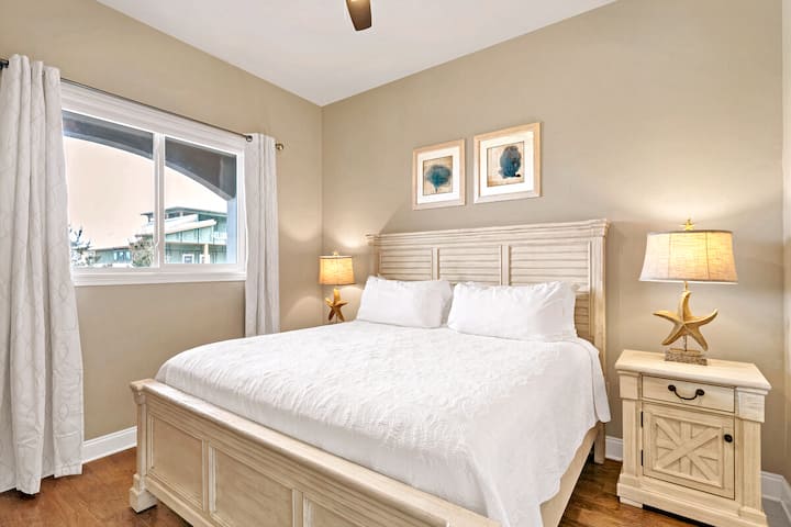 Chambre principale confortable avec lit king et literie blanche propre.