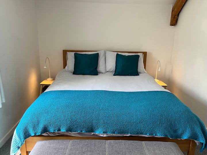 El dormitorio principal cuenta con una cama tamaño king, armarios empotrados y una hermosa vista sobre el jardín.