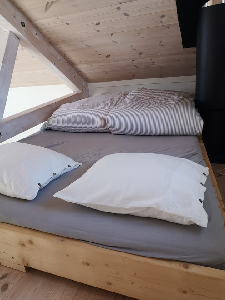 Double bed in the loft, custom made for space between oven pipes and roof beams (width 120 at the foot, 150 at head, oven pipe can provide extra warmth!)