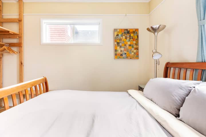 غرفة نوم في الطابق الرئيسي بسرير مريح بحجم كوين