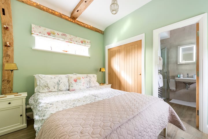 מיטת קינג סייז חדשה ונעימה בחדר השינה היפה שלנו עם שירותים צמודים.