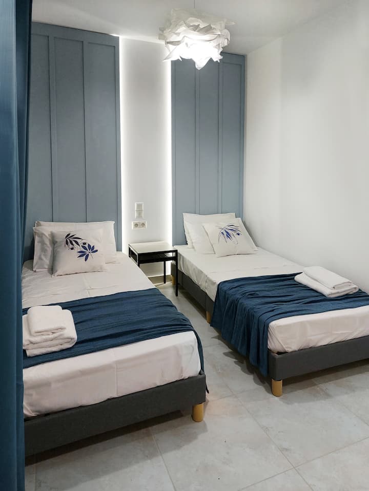 การออกแบบของห้องพักชาญฉลาดและใช้งานได้ดีมีโต๊ะข้างเตียงเพื่อความสะดวกของผู้เข้าพัก ด้านบนมีโคมไฟที่มีเอกลักษณ์เหมือนเมฆเปล่งประกายอ่อนๆผ่อนคลายช่วยเพิ่มบรรยากาศอันเงียบสงบของที่พักที่ประดับประดาด้วยโทนสีฟ้าที่ได้รับแรงบันดาลใจจากทะเล