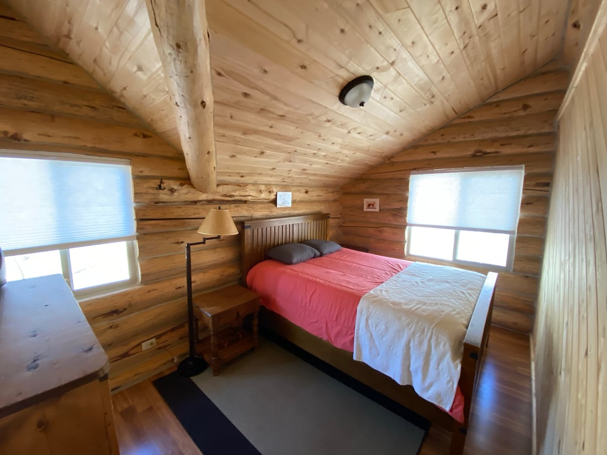 חדר שינה למעלה מס '1. מיטת קווין סייז.  החלון משקיף לכיוון עצי כותנה ומרעה.  