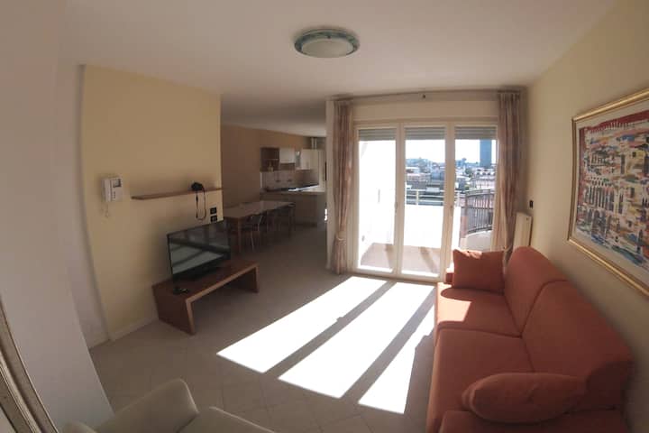 vue générale de l'espace entrée avec coin salon et vue sur la salle à manger et la terrasse au sud