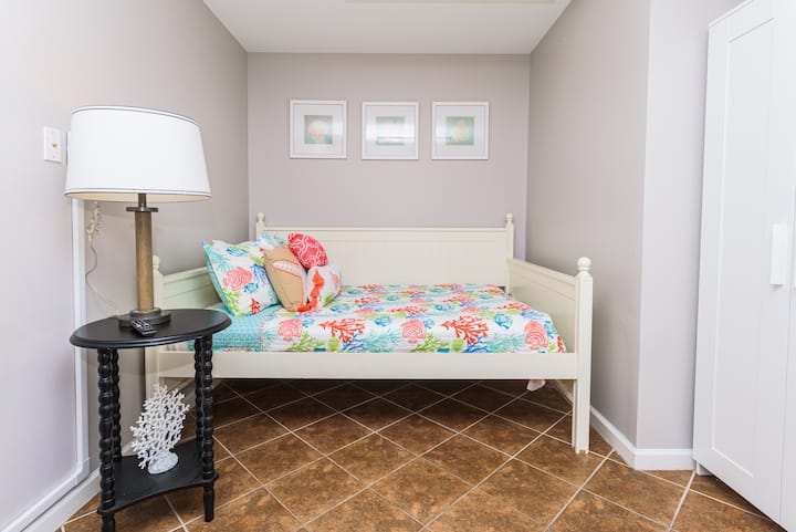 Spálňa na spodnom poschodí s plnohodnotnou pohovkou a 40-palcovým televízorom Samsung.