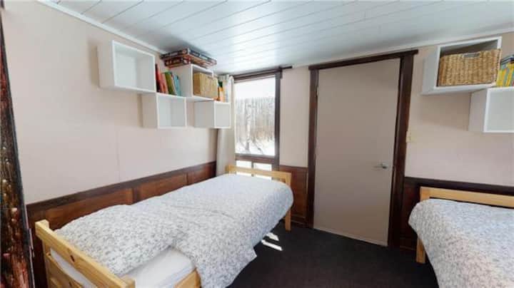 Left twin bed: there are fisherman boxes to keep clothing (one box has a wicker basket for your smaller belongings). There are hooks on the wall behind this bed to hang clothing.