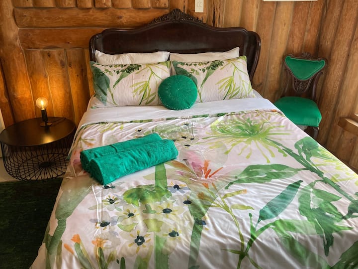 ห้องนอนสีเขียวมรกต 1 พร้อมเตียงโบราณขนาดควีนไซส์บนชั้น 2 ที่มีพื้นที่นั่งเล่น