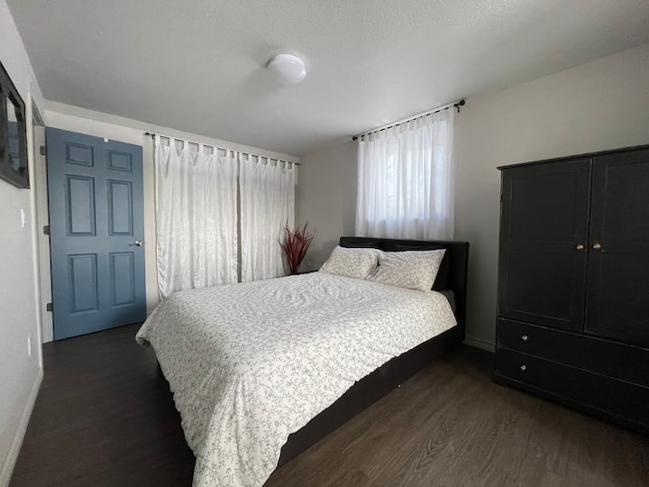 The master bedroom: a queen bed (bed has been updated and now has drawers as well), a closet, a free standing cupboard with drawers, two side tables (photo needs to be updated to show these) and a laundry basket