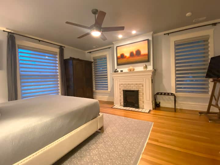 Chumba cha msingi cha kulala - Meko ya gesi inayodhibitiwa kwa mbali ya Cast Iron huunda mazingira mazuri, ya kimapenzi.  Mwonekano wa bustani ya Watson (treni) nje ya dirisha kubwa.