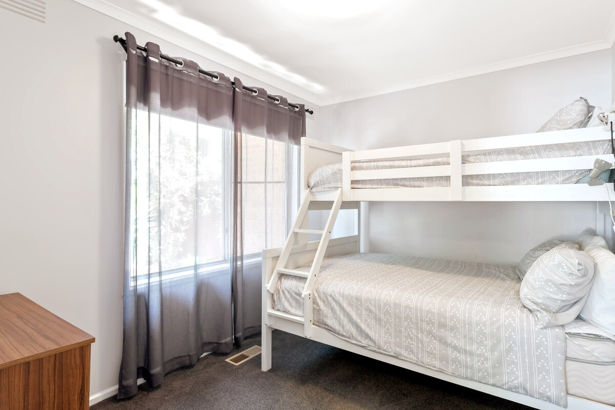 חדר שינה עם מיטה זוגית ומיטת יחיד עליונה