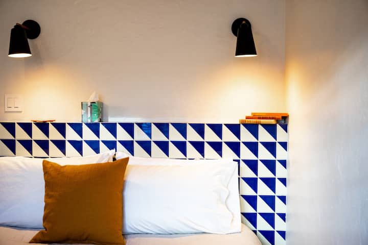 Relax in this inviting bedroom with crisp linens, bedside lighting, and a serene, minimalist design.