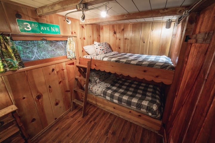 A través de un conjunto de puertas de estilo francés directamente junto a la mesa del comedor hay literas gemelas con taquillas vintage para guardar.