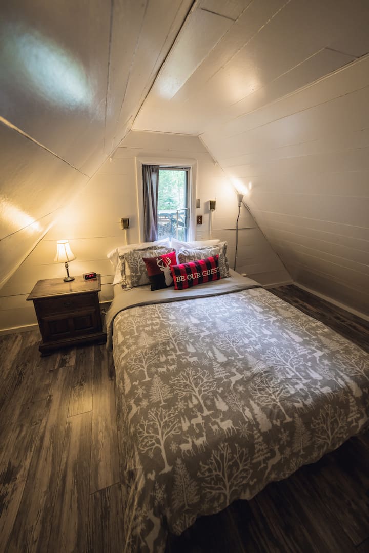Cama tamaño queen del segundo dormitorio con una ventana con vistas parciales al río.
