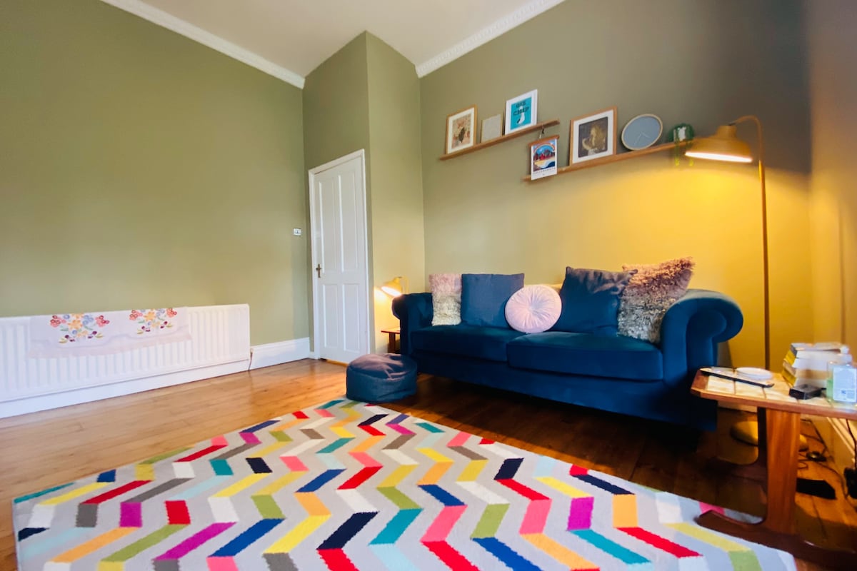 Sebule kubwa yenye dari ya juu, sofa, kiti cha mkono na kiti cha kubembea 