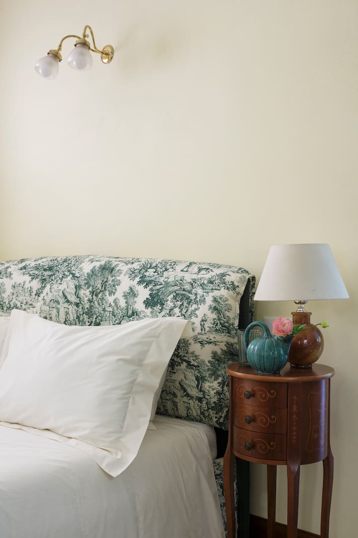 Particolare del comodino della prima camera da letto. Lenzuola in cotone Percalle