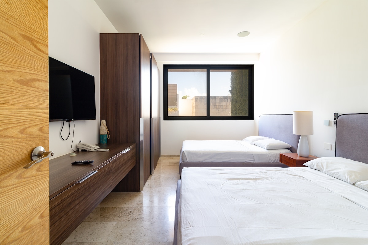 Chambre sont équipées de deux lits simples, une télévision et un grand placard, offrant confort et espace pour se reposer et profiter de votre divertissement préféré.