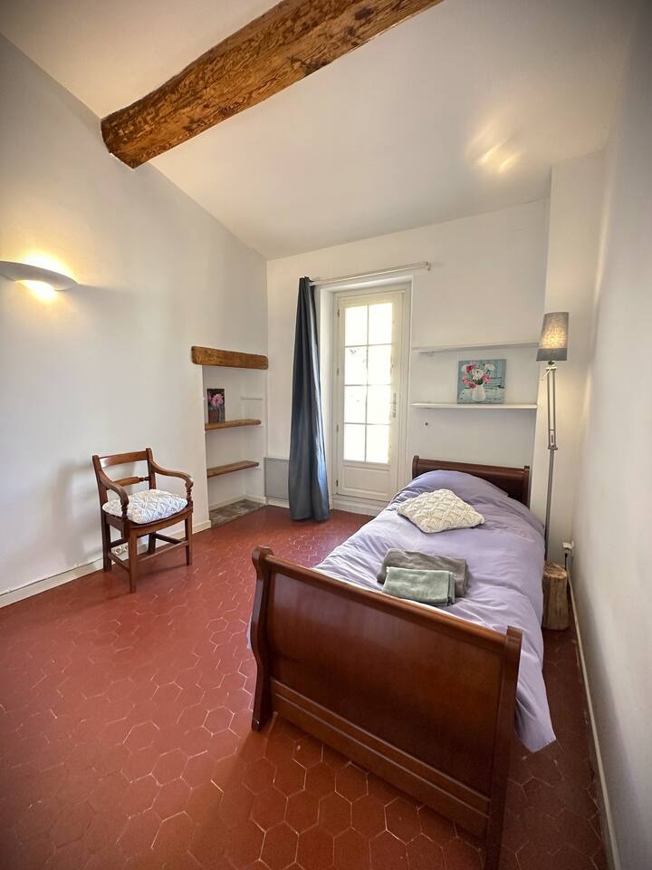 Slaapkamer 2 met uitzicht op het terras. Uitschuifbed en kastje.