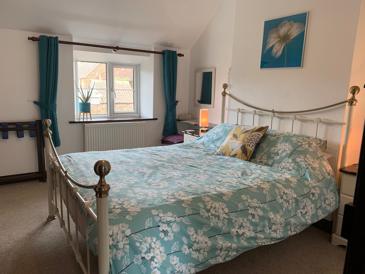 Glavna spavaća soba za goste s bračnim krevetom, priborom za pripremu čaja i kave te mini hladnjakom.