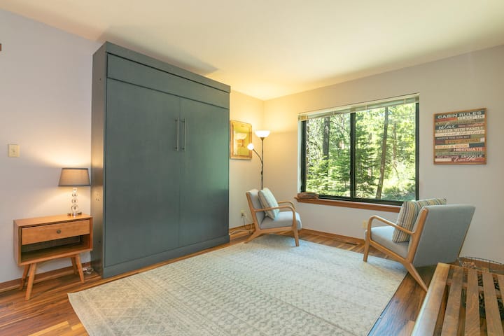 Downstairs Queen Bedroom coverts to a sitting room perfect for yoga or enjoying the forest views.