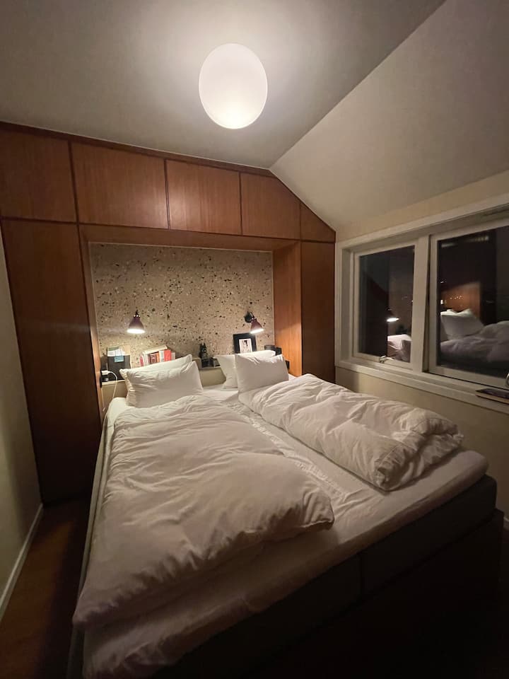 Hlavná spálňa s vlastnou kúpeľňou a dverami na balkón.