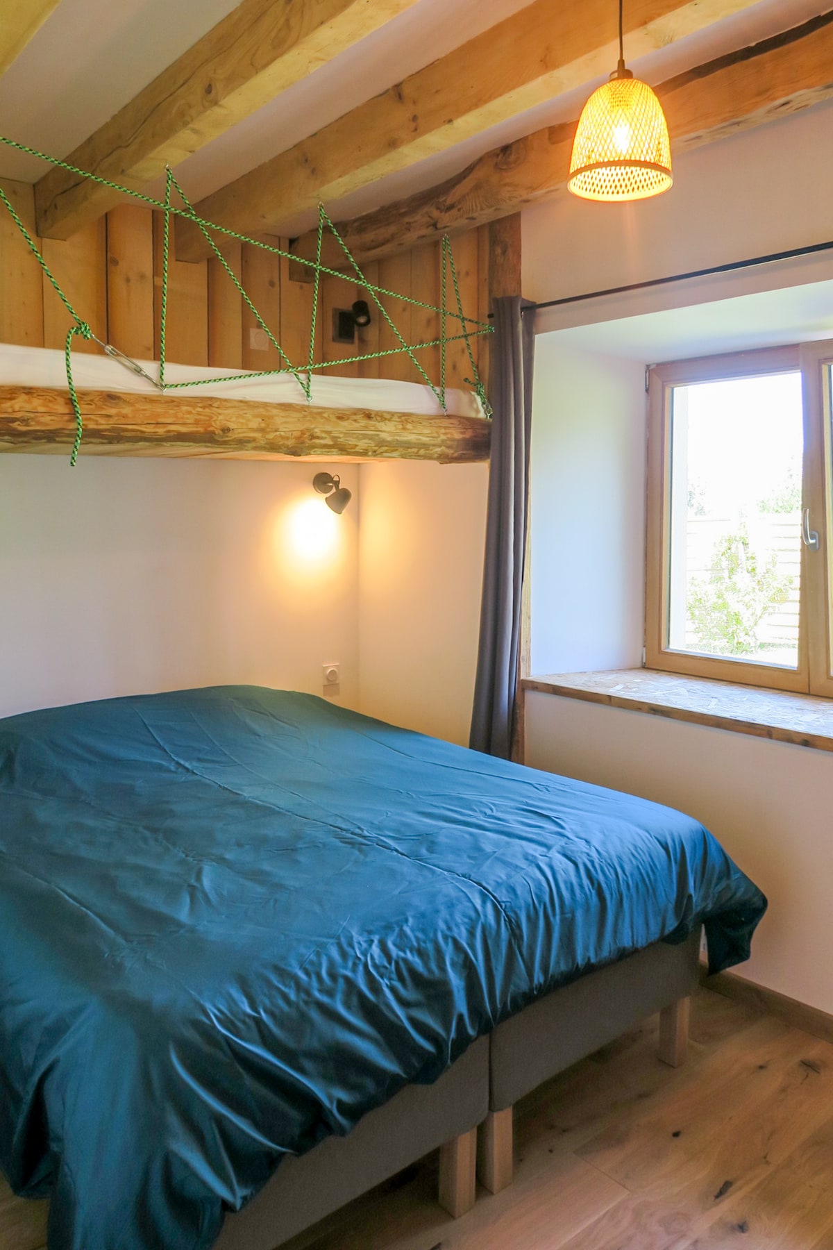 slaapkamer met tweepersoonsbed en bed in houten huisje