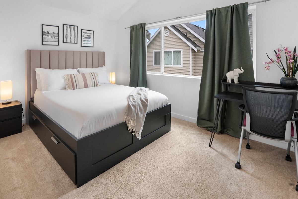 غرفة نوم ثانية واسعة بسرير بحجم كوين ومكتب عمل. 