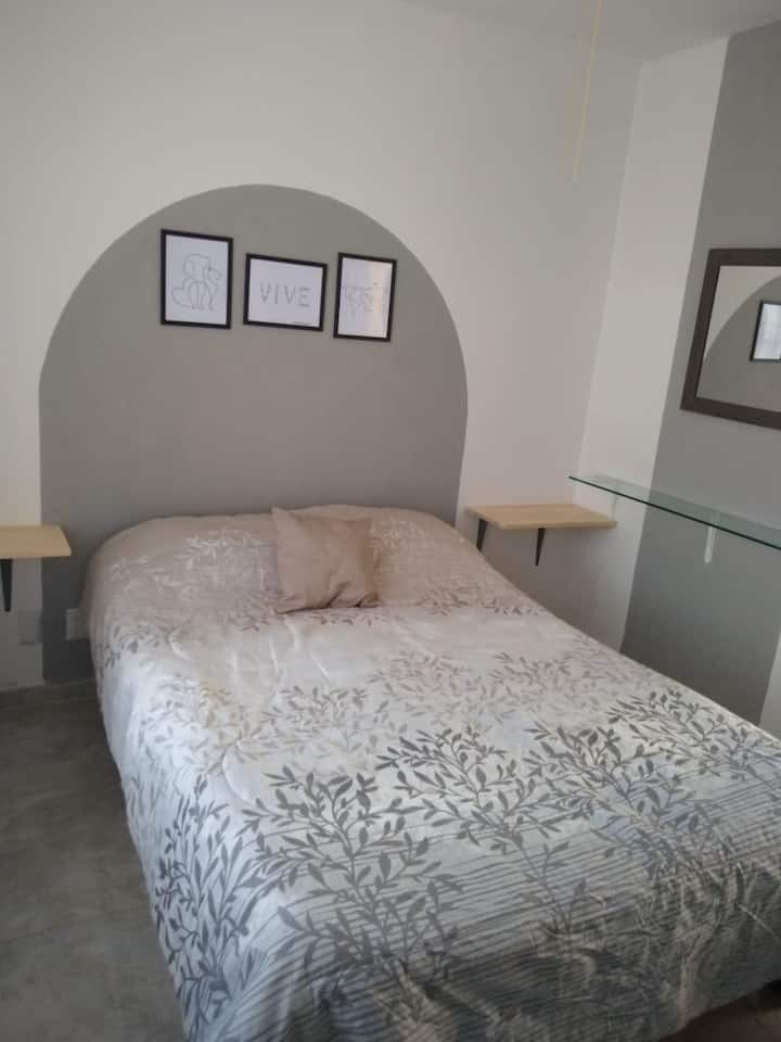 Recámara pricipal, cama matrimonial, closet, ventilador con lámpara y taburetes