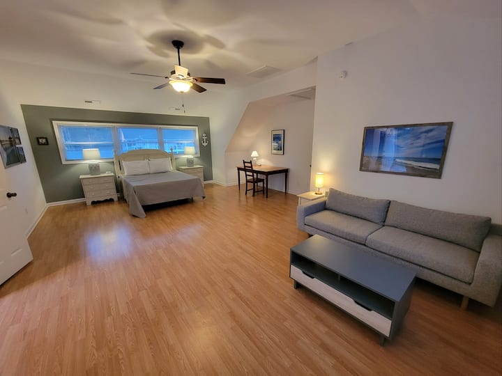 Dhomë gjumi kryesore me banjë, divan, televizor, tavolinë pune dhe verandë private