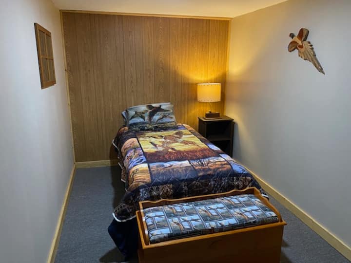 1 of 3 bedrooms in the basement with single beds.