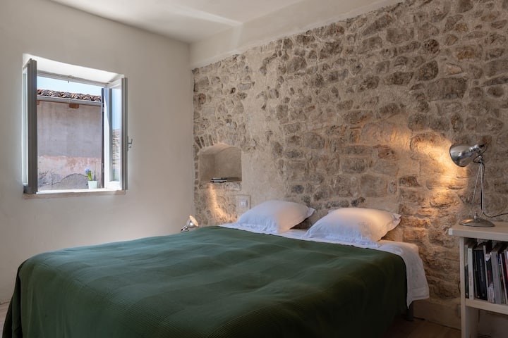 Prima camera con letto matrimoniale e vista sul campanile romanico/
غرفة أولى بسرير مزدوج وإطلالة على برج الجرس الروماني