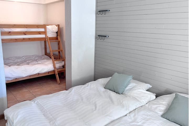 غرفة عائلية في الطابق السفلي مع سرير مزدوج وطابق مع سرير بحجم كوين في الأسفل