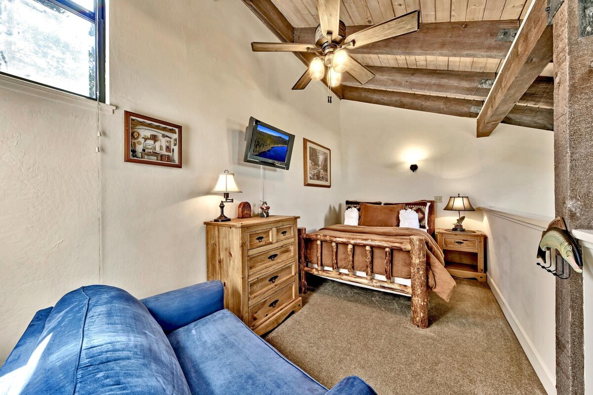 三楼阁楼是开放的，可俯瞰客厅。这里有一张双人床、吊扇、高清电视和可爱的小木屋装饰 