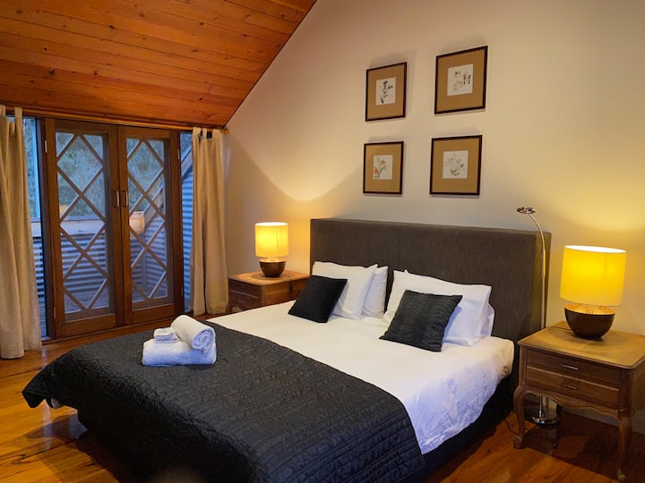 Large King bedroom with balcony, comes with wir, private ensuite; spa bath, vanity, toilet.  Allow the alpine air to flow through balcony doors while sleeping to allow for the best night's sleep in the valley! Includes a small TV with DVD player.