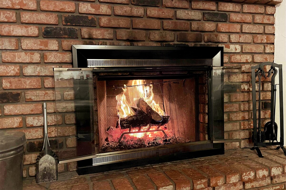 استمتع بالدفء بالقرب من المدفأة التي تعمل بالخشب مع فيلم أو ألعاب لوحية!