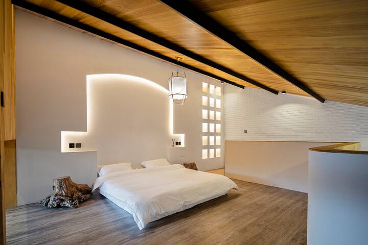 设计师在卧室床头墙壁上做了内嵌式拱顶设计，柔软的曲线轮廓给人以视觉上的延伸之感