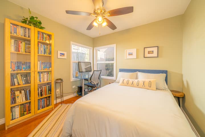Bedroom #3 with collection of travel books and good reads! The comfortable workspace has lots of natural lighting and an adjustable water feature just outside the window for a peaceful nights rest.