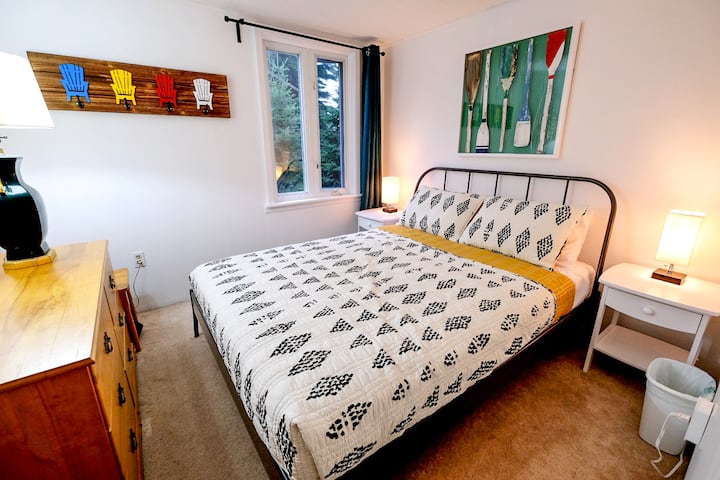 Master bedroom featuring a queen size bed, bedside lamps with USB ports for easy charging, and blackout curtains to help you sleep in.