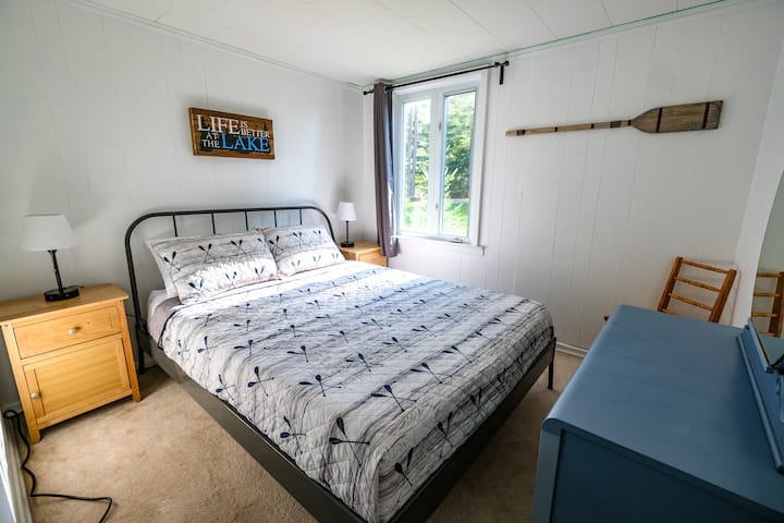 The Paddle Room features a queen bed with table lamps with USB and 3-prong outlets for convenient charging. Grey blackout curtains make it easy to sleep in. 