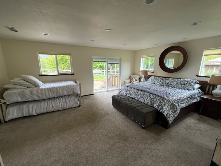 Glavna spavaća soba.  Veliki bračni krevet, dva blizanca u pomoćnom krevetu. Klizna staklena vrata otvaraju se prema vanjskoj terasi sa stolom i stolicama. 