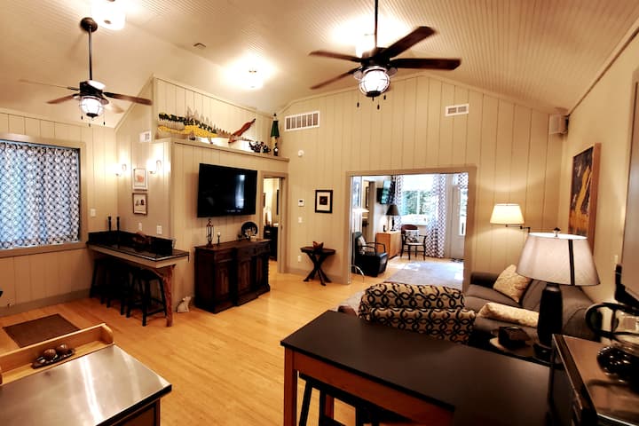 The living room has a big-screen TV, surround sound, and Bluetooth capability. It also includes a pull-out sofa bed. 