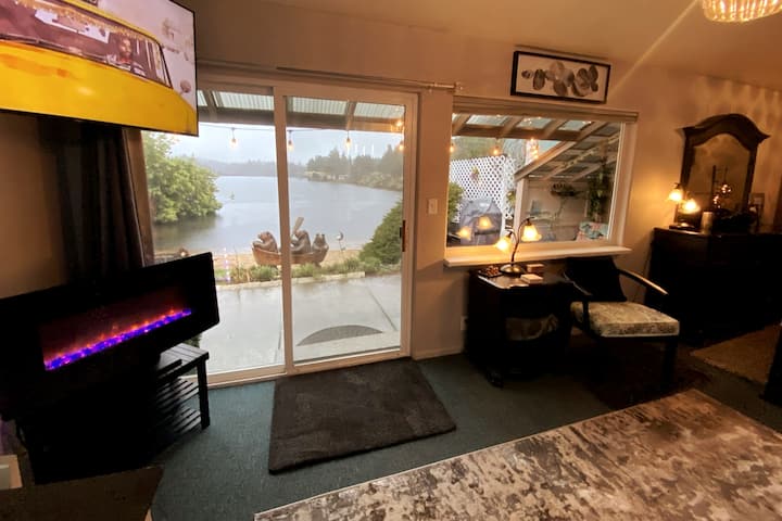 Living area with color changing fireplace, dining table and 50" flat screen TV.  Couch folds out to full sized bed