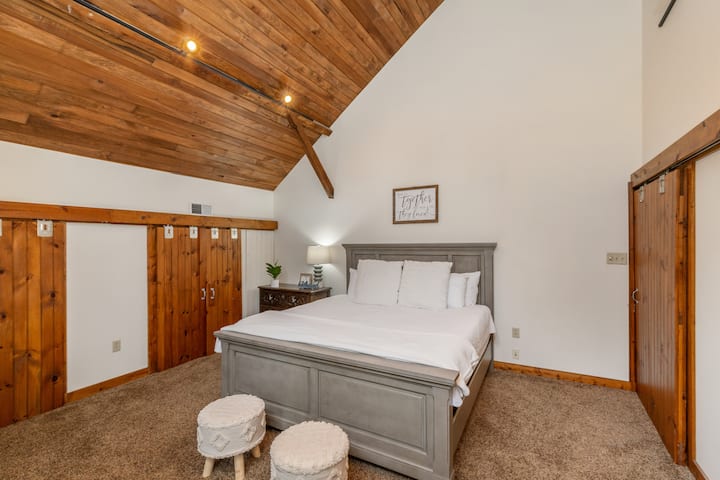 ห้องนอนคิงไซส์พร้อมงานไม้ในโรงนาดั้งเดิมและเพดานโค้ง