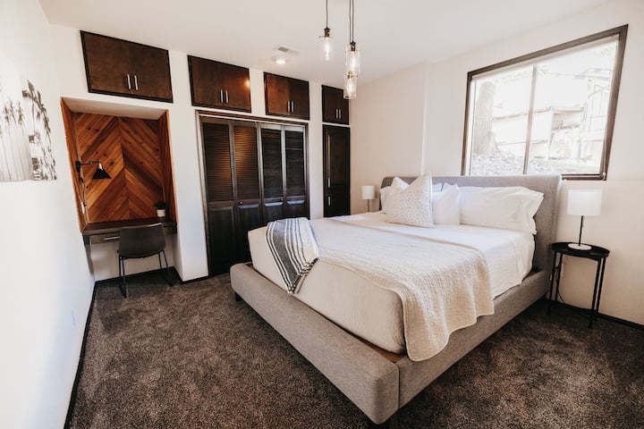 Downstairs Guestroom with King size Bed and a designated workspace with USB ports for charging.