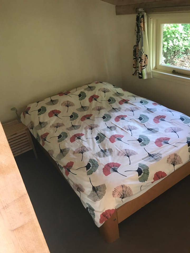 חדר השינה עם המיטה הכפולה. חדר השינה אינו במפלס אחד. זה קצת נמוך יותר מהסלון. אתם מגיעים לשם דרך גרם מדרגות עם שלב אחד. 